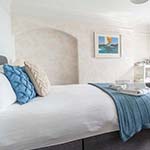 bed decorated with blue blankets and cushions