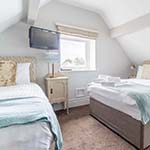 2 beds and a tv in a bedroom