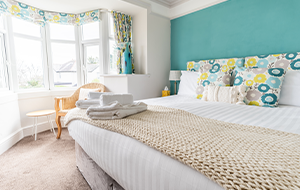 large window in a bedroom with towels on the bed